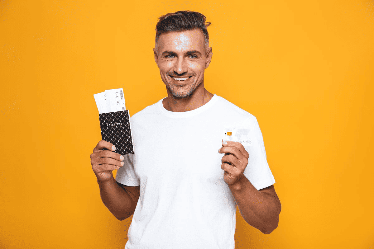 A passport card and a passport book with a plane in the background